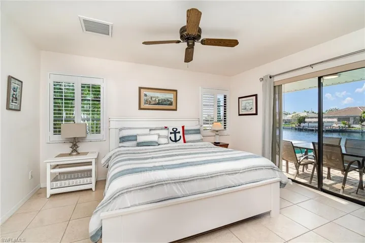 Guest Full bath with 2 sinks, a vanity, tiled shower, tile patterned floors, and toilet