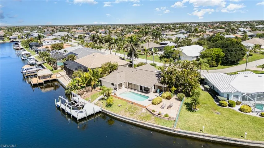 Aerial view of residentialarea showing the pool, patio, boat lift, 135' seawall and all on the Gulf Access "Splendor" canal