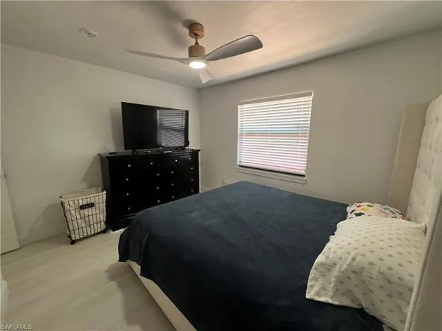 Bedroom with a closet, ceiling fan, and dark wood-style floors