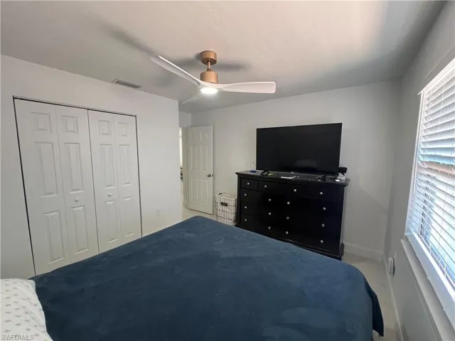 Kitchen featuring white cabinetry, a peninsula, stainless steel appliances, a breakfast bar, and decorative backsplash