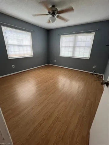 Unfurnished room featuring light wood-type flooring, a textured ceiling, and ceiling fan