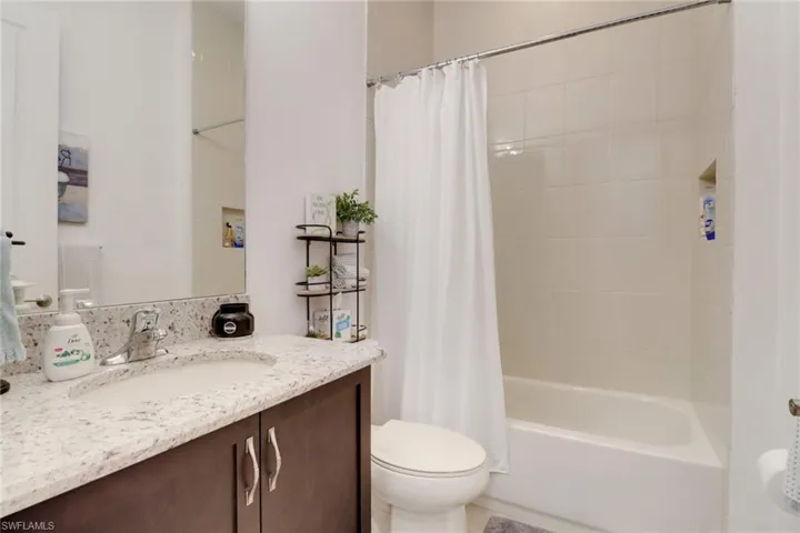 Full bathroom with toilet, vanity, and shower / bath combo