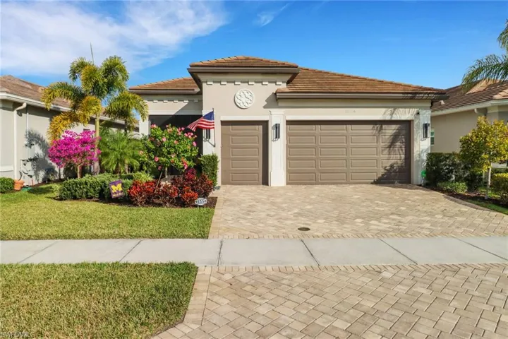 View of front of property featuring a front lawn and a garage