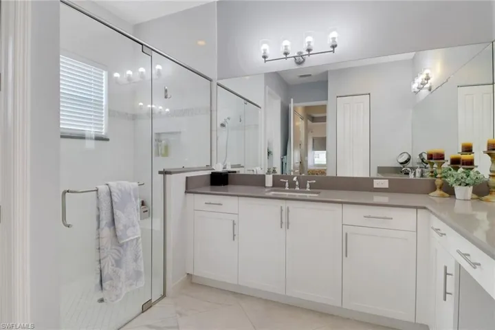 Bathroom featuring an enclosed shower and vanity