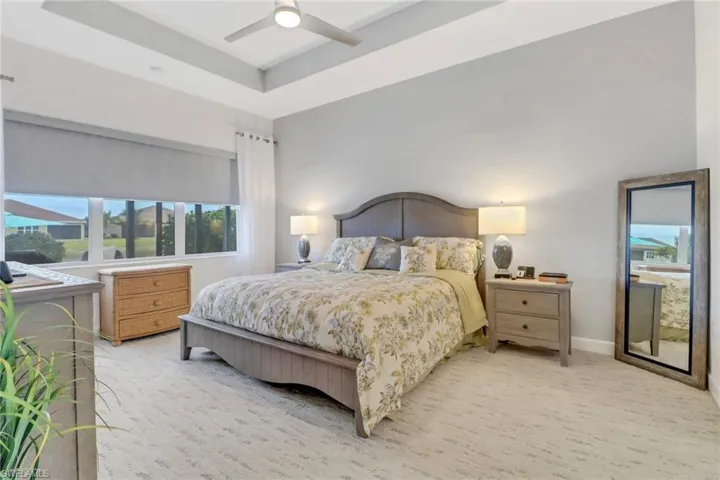 Bedroom featuring ceiling fan and a tray ceiling