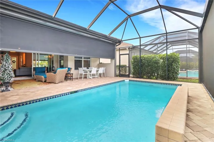 View of pool with an outdoor hangout area, a patio area, and a lanai