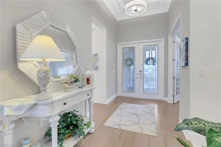 Entryway featuring ornamental molding, french doors, and light hardwood / wood-style floors