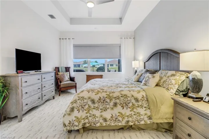 Bedroom with ceiling fan and a tray ceiling