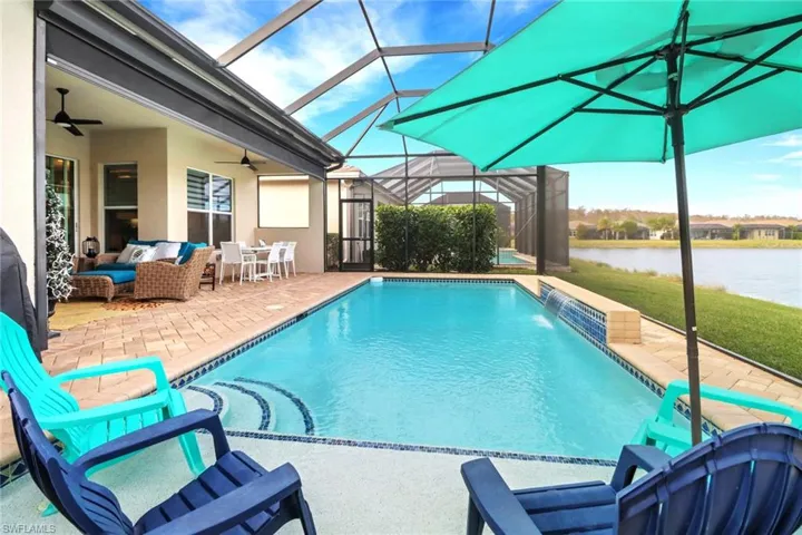 View of swimming pool with ceiling fan, pool water feature, a water view, an outdoor hangout area, and a patio