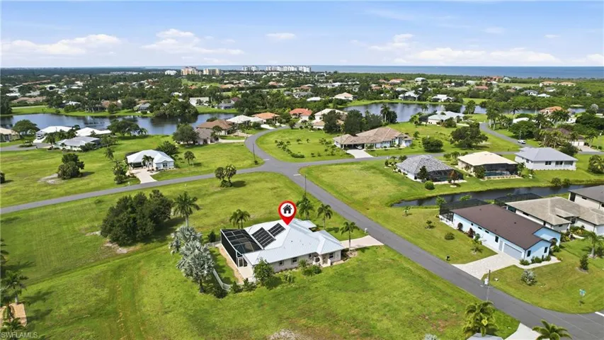 Sprawling property featuring a modern residence with a silver metal roof situated on manicured grounds surrounded by expansive greenspace.