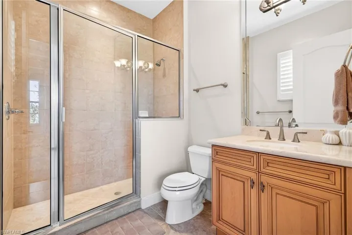 Bathroom featuring a stall shower, vanity, and light tile patterned floors