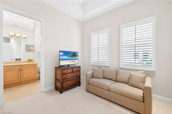 Living area featuring light carpet and baseboards