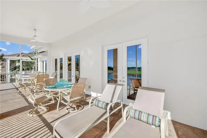 View of patio featuring a sunroom, ceiling fan, outdoor dining space, and a water view