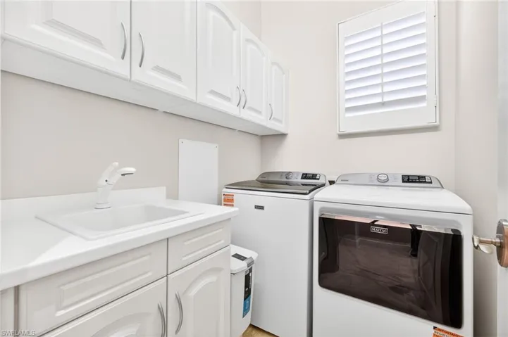 Washroom featuring cabinet space and independent washer and dryer