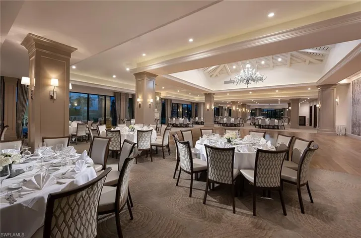 Dining area with a tray ceiling, recessed lighting, a chandelier, and decorative columns