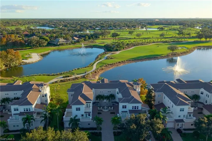 Aerial perspective of suburban area featuring a nearby body of water and a golf course