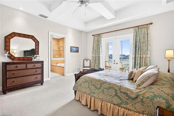 Carpeted bedroom with french doors, beam ceiling, access to exterior, a ceiling fan, and ensuite bathroom