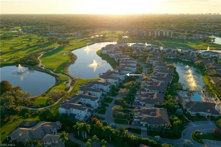 Aerial perspective of suburban area with a nearby body of water and a golf course