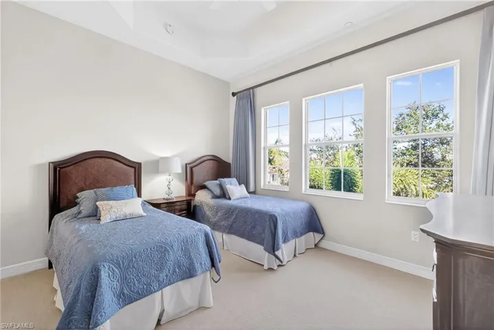 Bedroom featuring carpet floors, a ceiling fan, and a raised ceiling
