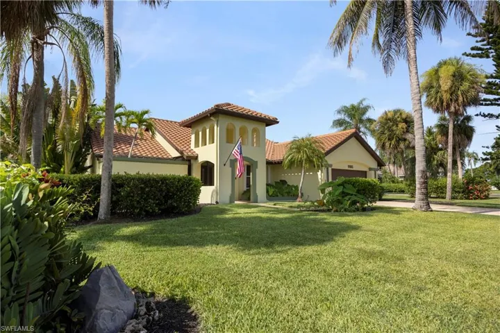 Mediterranean-inspired exterior with a prominent tower, terracotta tile roof, and an attached garage
