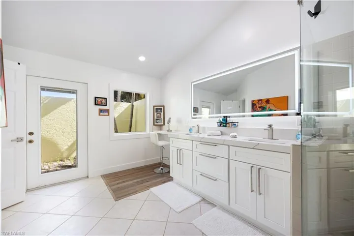 Dual vanity with white cabinetry, integrated sinks, and brushed nickel faucets