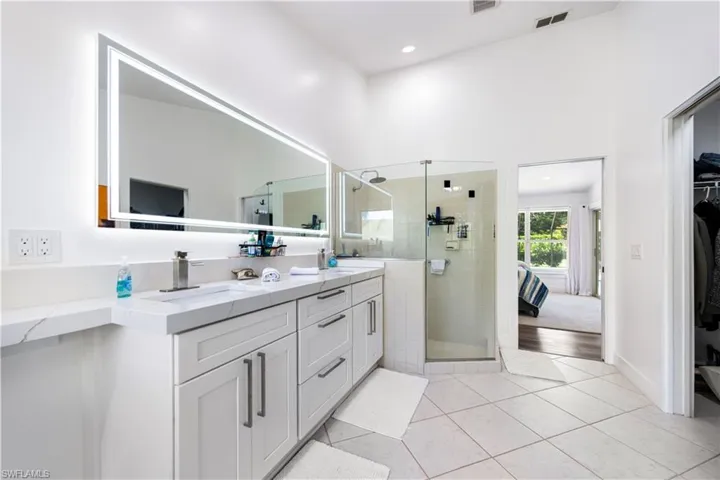 Spa-inspired primary bathroom featuring a floating vanity with dual sinks, quartz countertop, and polished chrome hardware