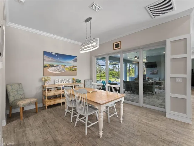 Dining room featuring crown molding, wood finished floors, a ceiling fan, and a chandelier