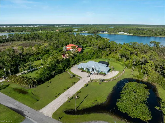 Aerial overview of property's location featuring a large body of water and a heavily wooded area