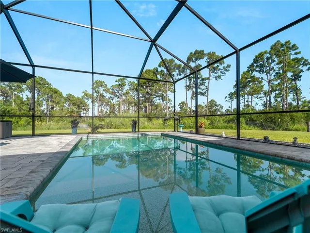 Outdoor pool featuring a sunroom and glass enclosure
