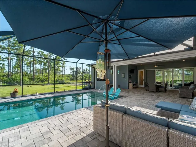 Outdoor pool featuring an outdoor living space, a lanai, a patio area, and a sunroom
