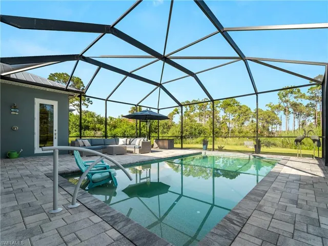 Outdoor pool with a sunroom, a lanai, a patio area, and an outdoor living space