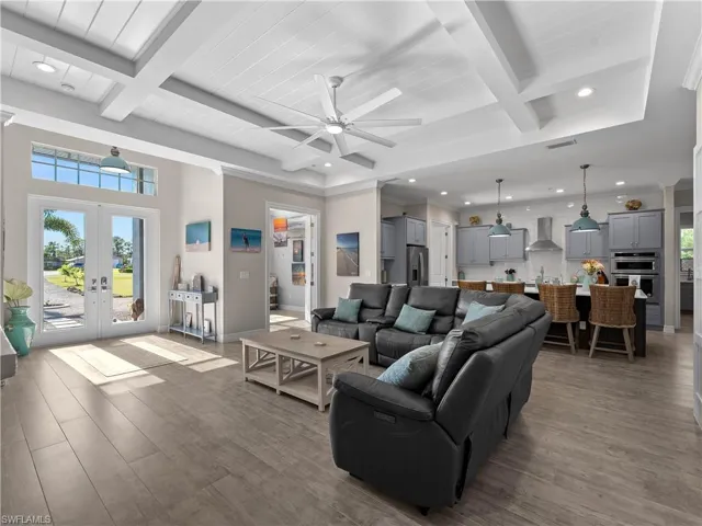 Living area with beam ceiling, coffered ceiling, a ceiling fan, light wood finished floors, and recessed lighting