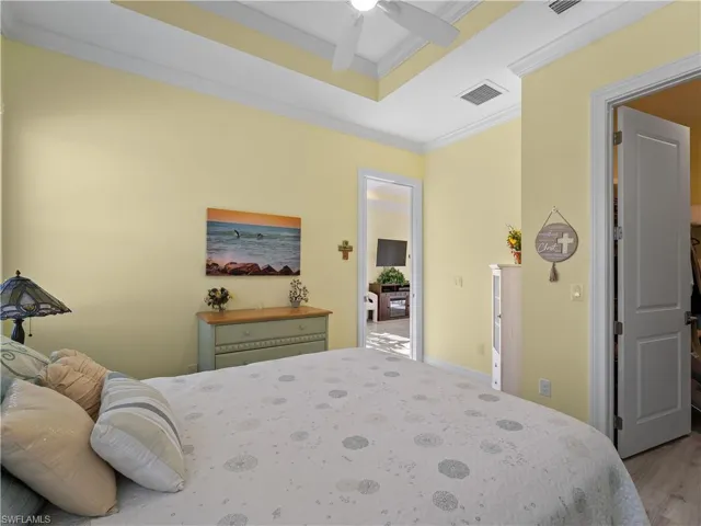 Bedroom with crown molding, light wood-type flooring, and ceiling fan