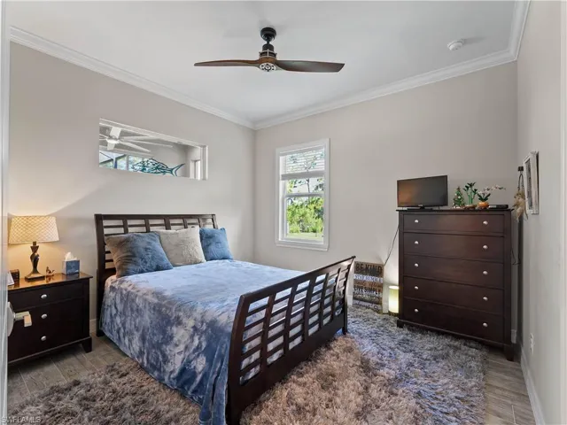 Bedroom featuring ornamental molding, wood finished floors, and ceiling fan