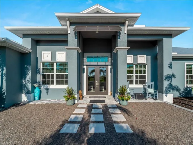 Property entrance featuring stucco siding and french doors