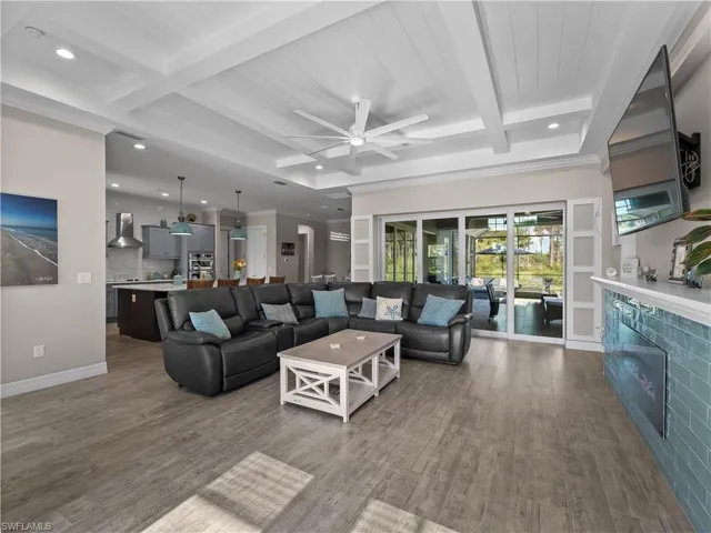 Living room with beam ceiling, coffered ceiling, a ceiling fan, dark wood finished floors, and recessed lighting