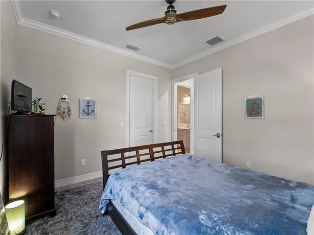 Bedroom featuring ornamental molding, ceiling fan, carpet, and ensuite bathroom