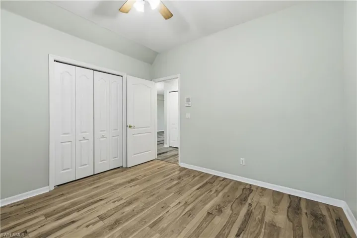 Unfurnished bedroom with light wood-type flooring, ceiling fan, a closet