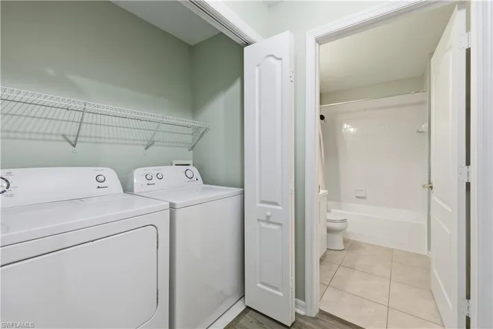 Laundry area featuring washing machine and dryer and light tile patterned floors