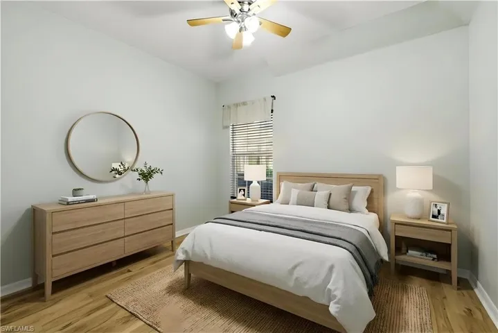 Staged Bedroom with ceiling fan and light wood-style flooring