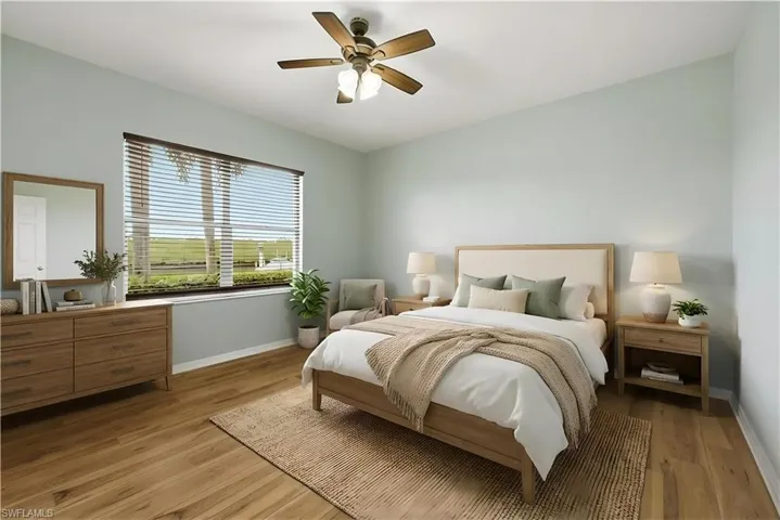 Staged Bedroom with light wood finished floors and a ceiling fan