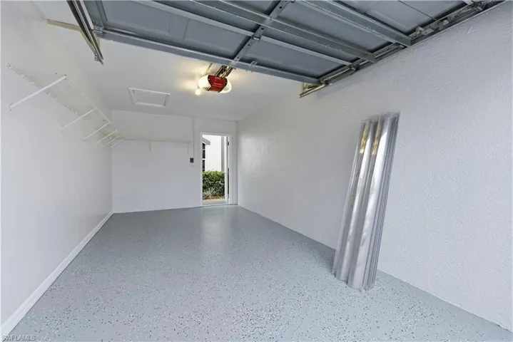 Garage featuring a garage door opener and a textured wall, newly painted