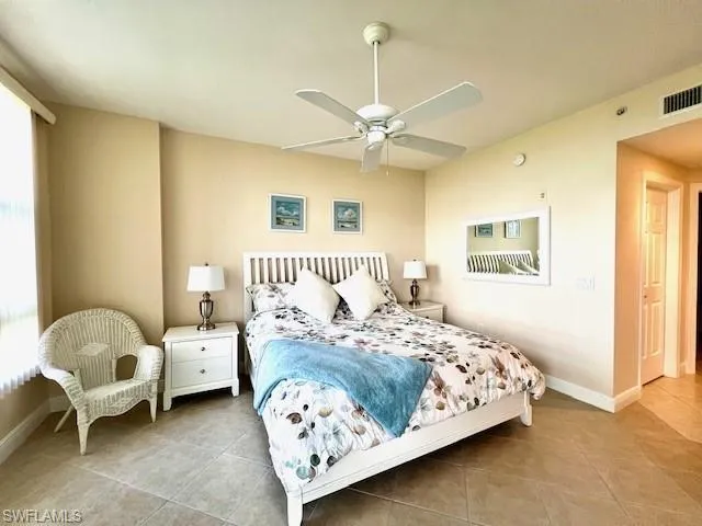 Bedroom featuring a ceiling fan, tile patterned floors, baseboards, and visible vents