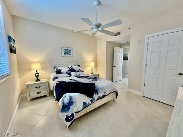 Bedroom featuring light tile patterned floors, visible vents, baseboards, and a ceiling fan
