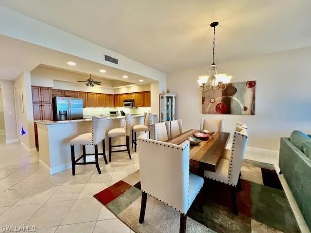 Dining room with visible vents, a notable chandelier, recessed lighting, light tile patterned floors, and baseboards