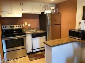 Kitchen with stainless steel appliances, ventilation hood, white cabinets, a peninsula, and a sink