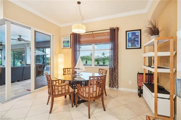 Dining space featuring baseboards, crown molding, light tile patterned floors, and a ceiling fan