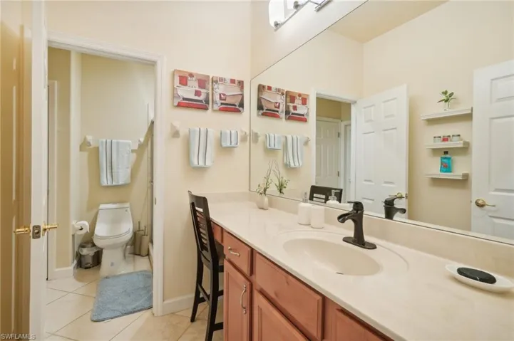 Bathroom with tile patterned floors, toilet, baseboards, and vanity