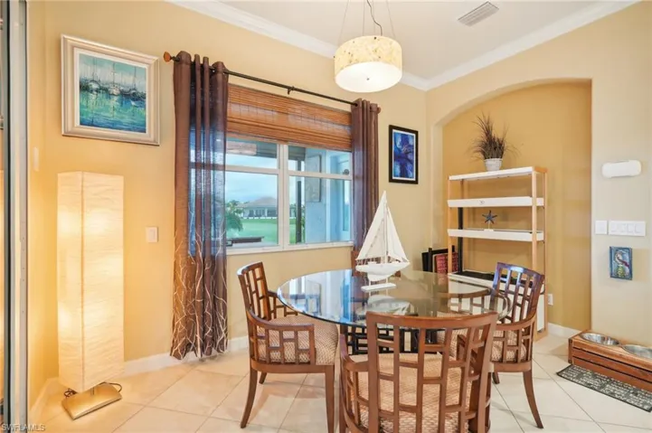 Dining room featuring baseboards, ornamental molding, visible vents, and tile patterned flooring