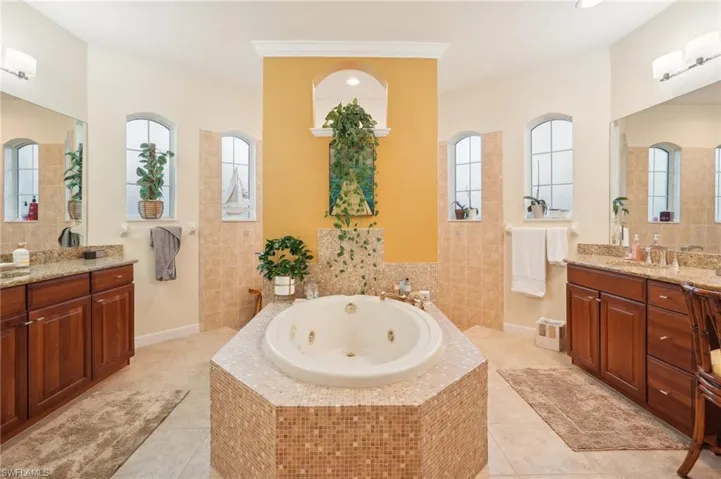 Bathroom with plenty of natural light, tile patterned floors, and a jetted tub